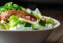 Cremigen, hellbraunen japanischen Sesam-Miso-Dressing, das über frischen knackigen Eisbergsalat gegeben wurde